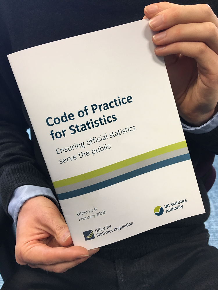 Pair of hands holding the refreshed Code of Practice