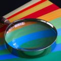 A magnifying glass on top of coloured paper
