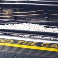 A train station platform that has Mind The Gap written on it in yellow paint