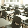 A photo of an exam hall with rows of empty plastic chairs
