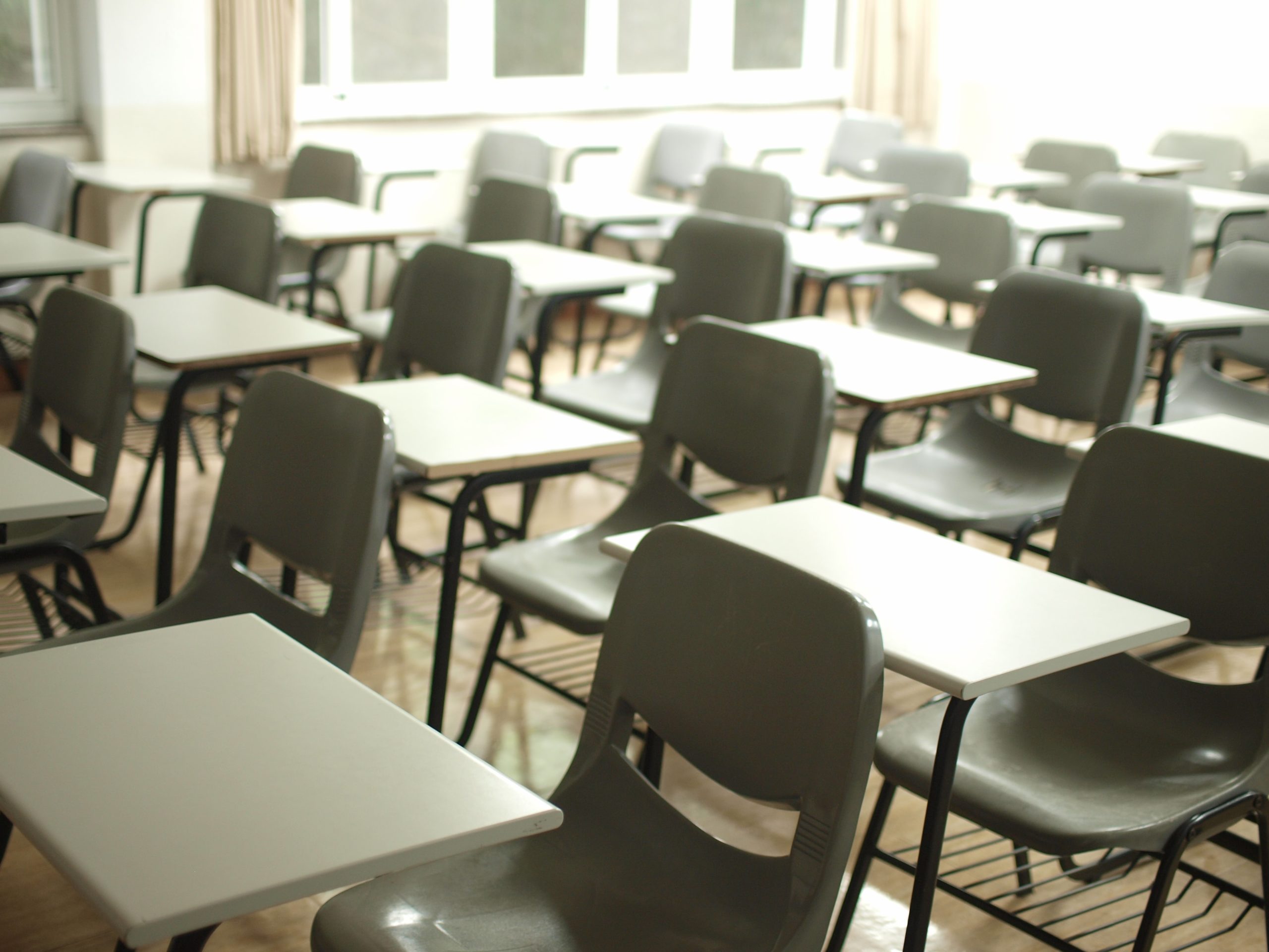 A photo of an exam hall with rows of empty plastic chairs