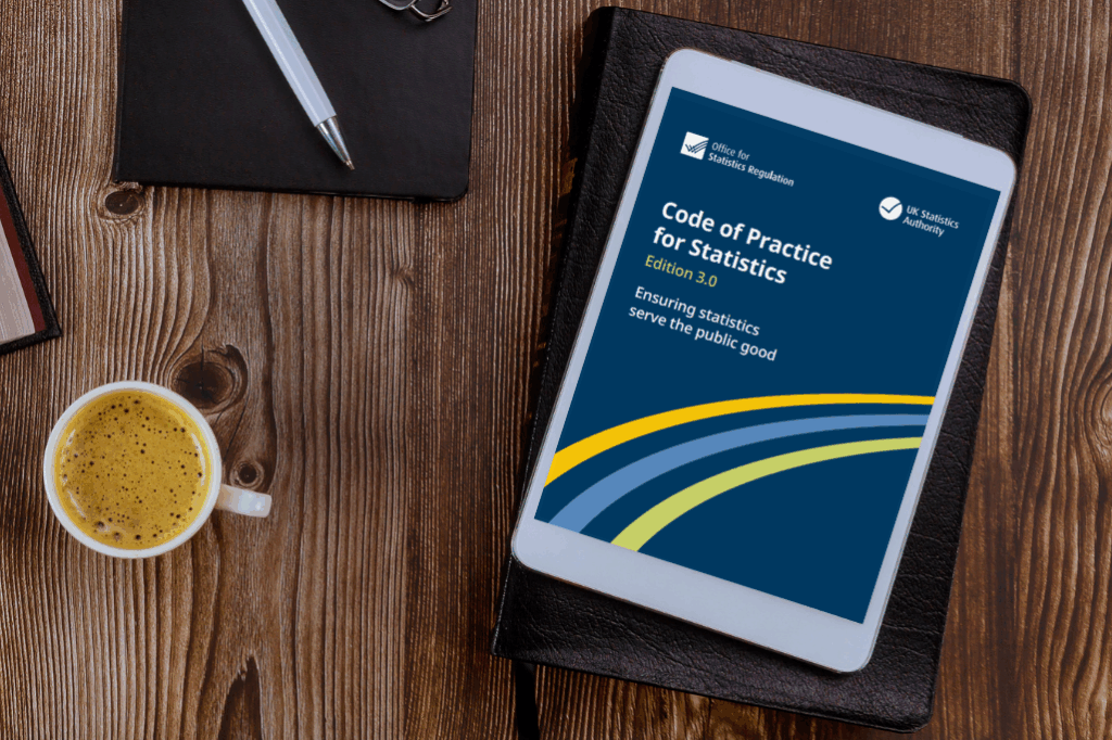 A tablet screen resting on a desk next to a cup of coffee - the tablet is displaying the Code of Practice for Statistics edition 3.0
