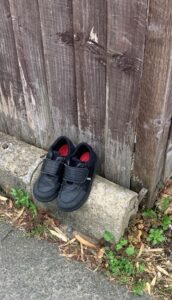 A picture of a pair of shoes outside a house