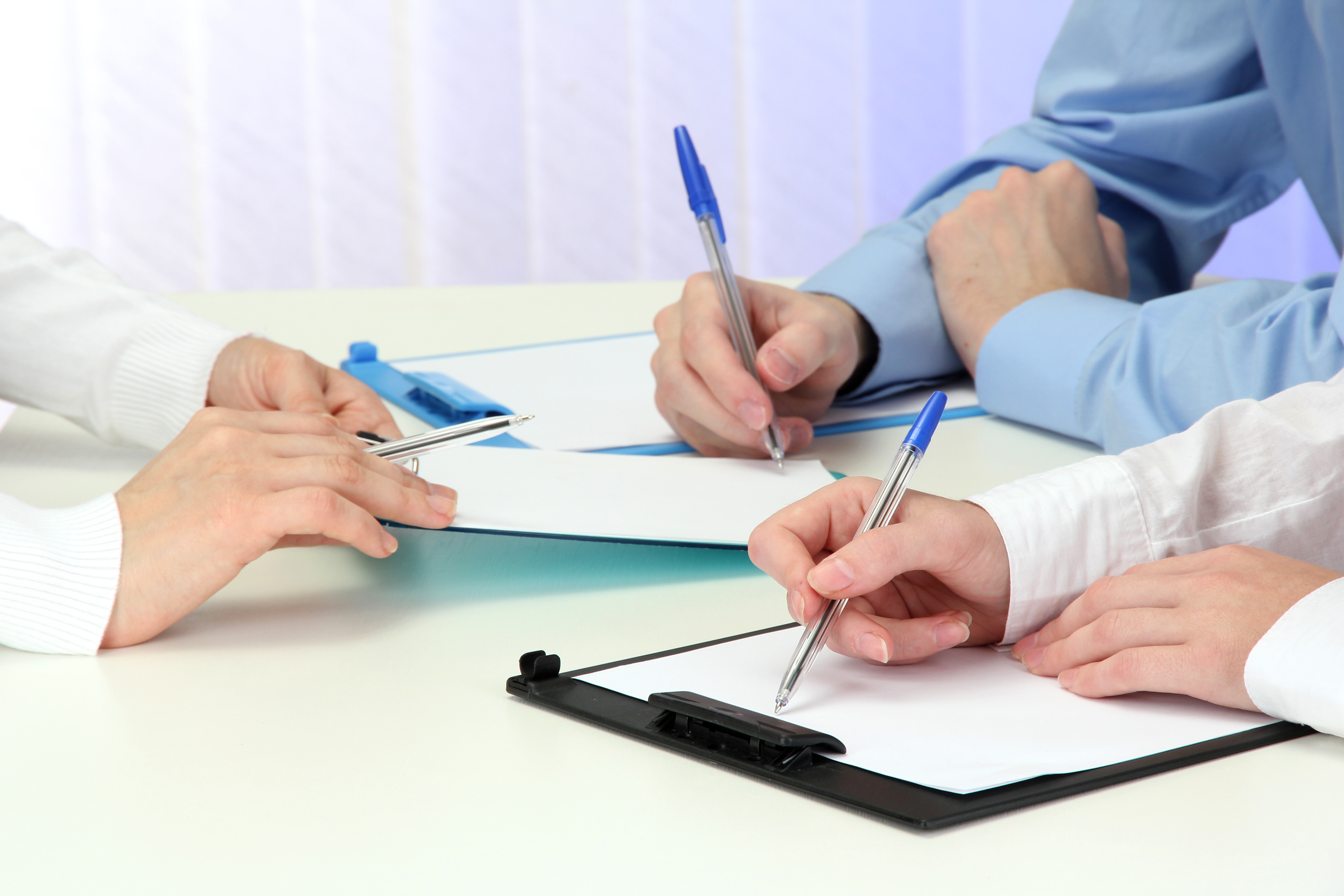TThree people with blue pens
