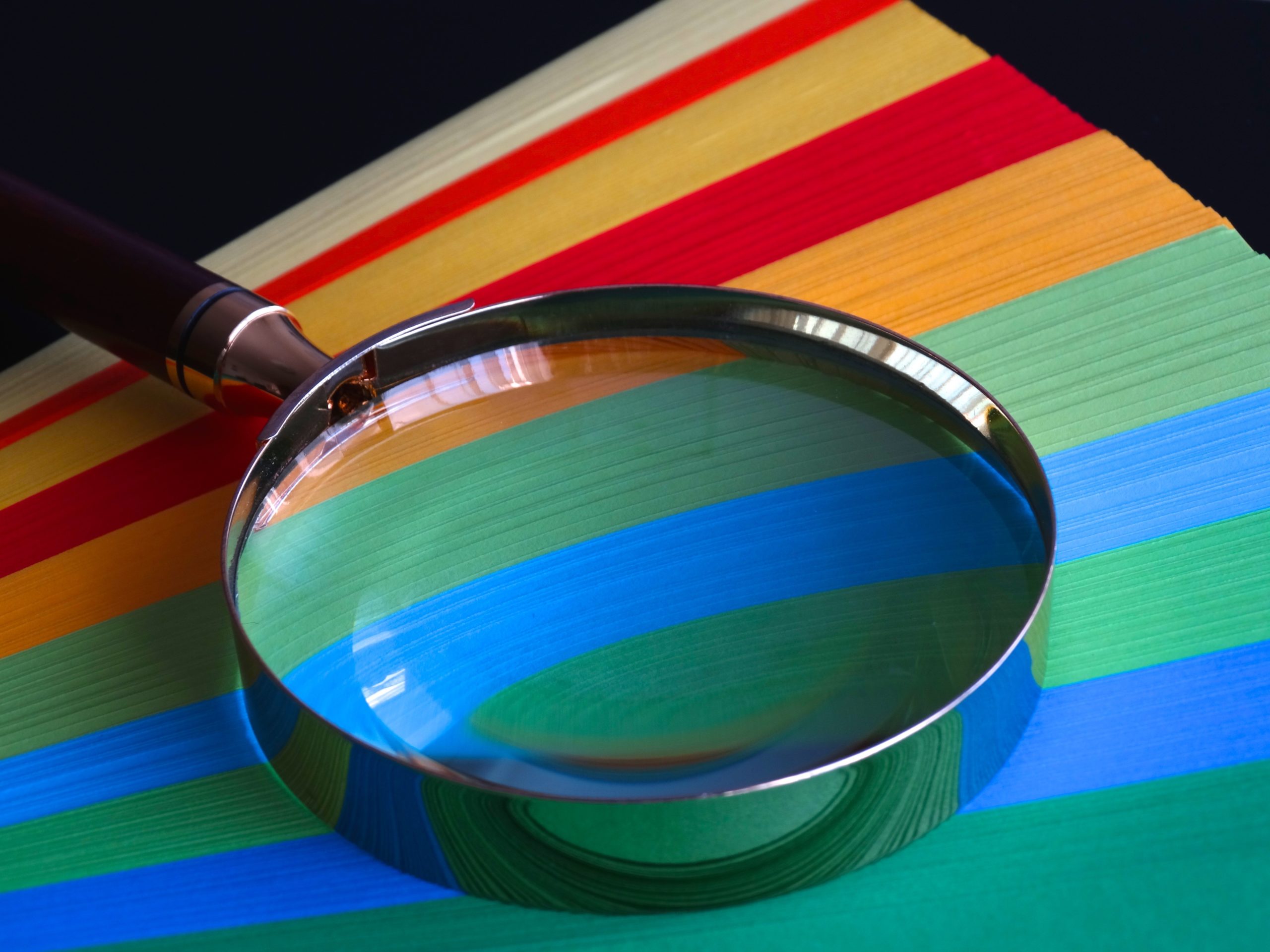 A magnifying glass on top of coloured paper