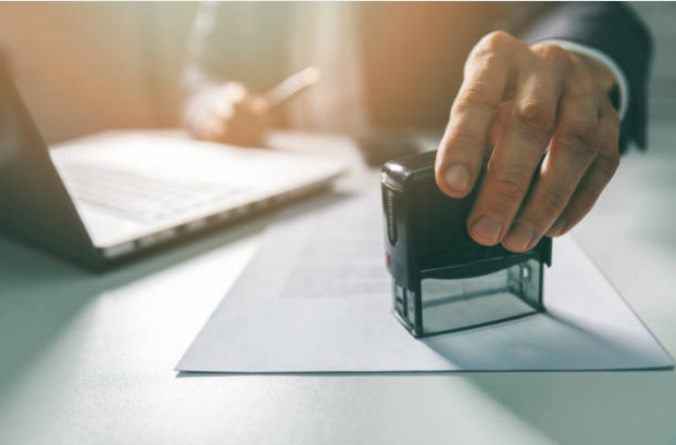 close up of a man stamping a document