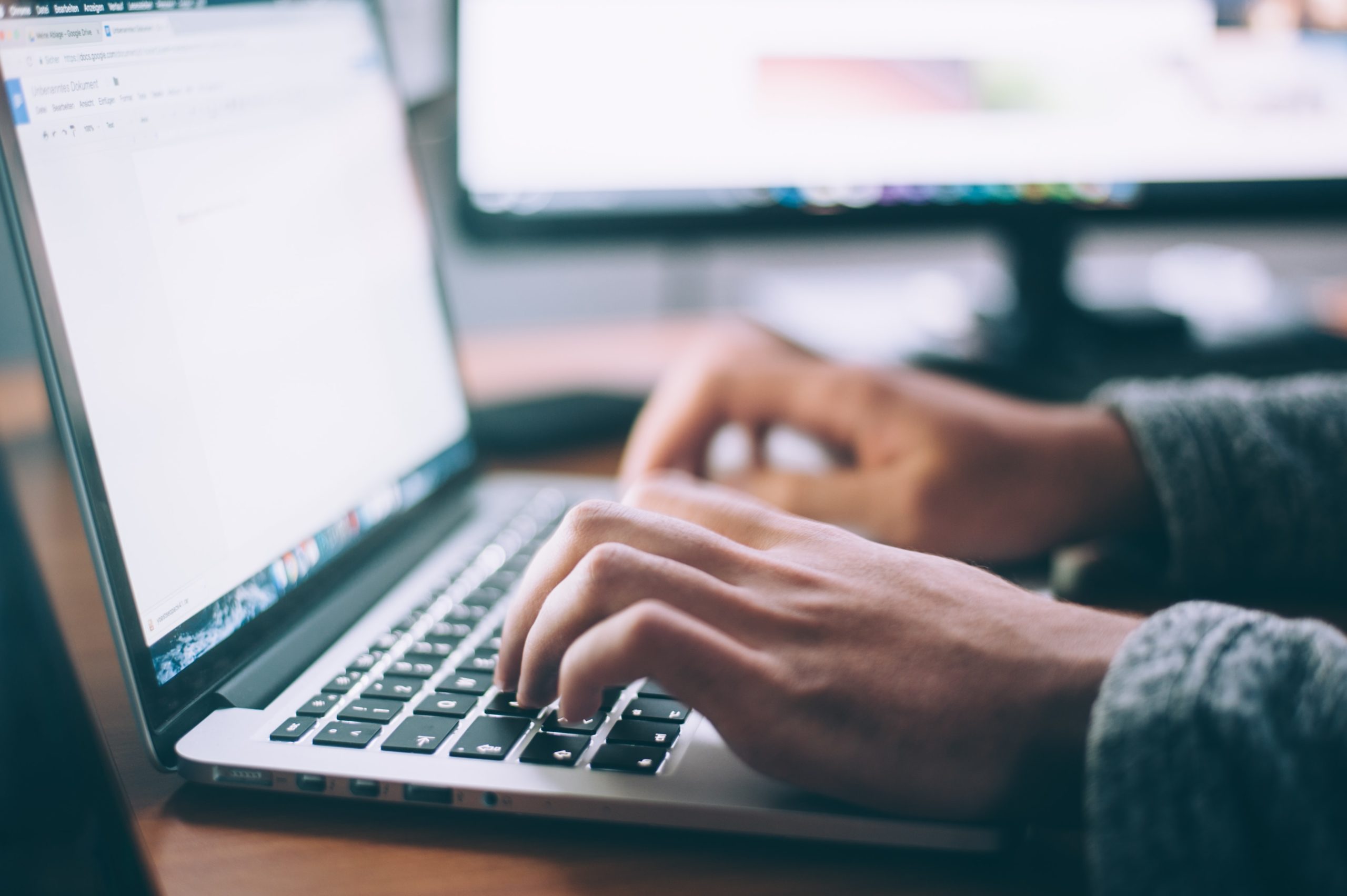 A photo of someone typing on a laptop