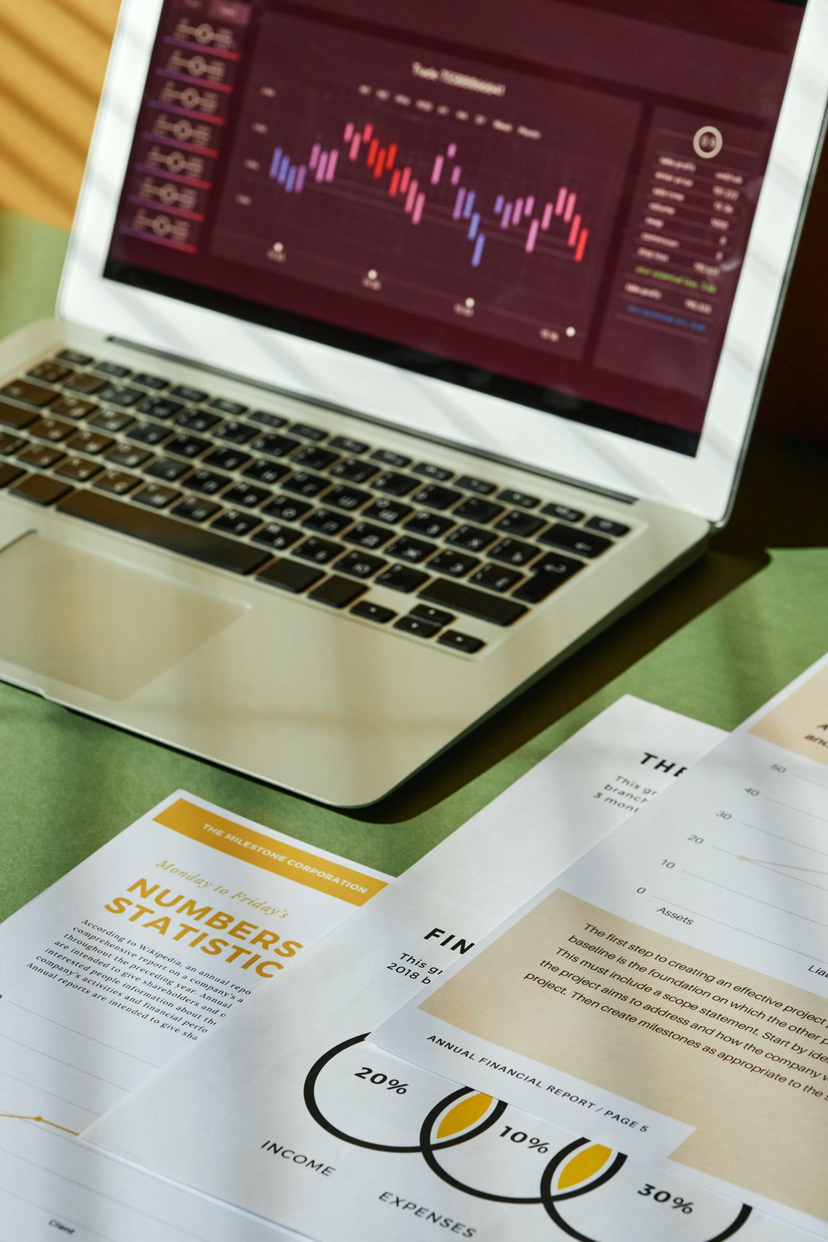 A laptop and document showing statistic charts