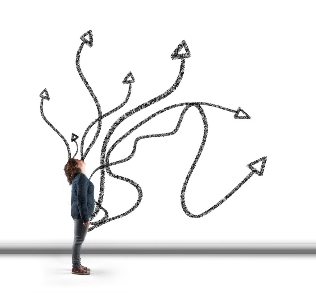 Woman standing in front of a wall drawn with different arrows.