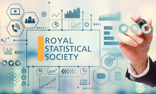 A white board covered in graphs and statistics with a hand drawing on it. The RSS logo in the centre