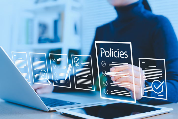 Decorative image of a person working on a laptop with policies icons
